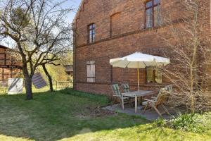 a table with an umbrella next to a brick building at Ferienwohnung am Roten Schloss in Glashütte