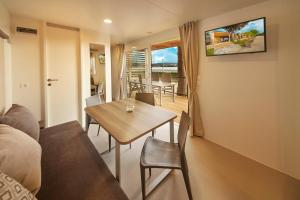 a living room with a table and a couch at Premium Mobile Homes - Hotel & Resort Adria Ankaran in Ankaran