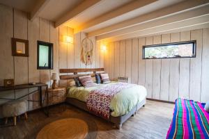 a bedroom with a bed in a room with wooden walls at Punta Ballena Lodge in Pichilemu