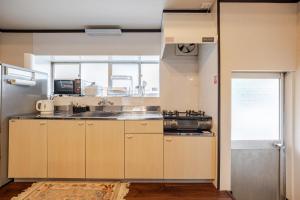 a kitchen with wooden cabinets and a sink at 鸛雀庵Kanjyaku-an in Nakatsugawa