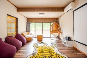 a living room with purple couches and a tv at 鸛雀庵Kanjyaku-an in Nakatsugawa