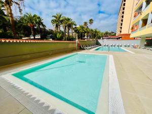 a swimming pool at a hotel with palm trees at El Estudio de Johanna in Puerto de la Cruz