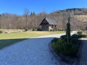 a cobblestone driveway with a house in the background at Apartament Łostówka in Łostówka