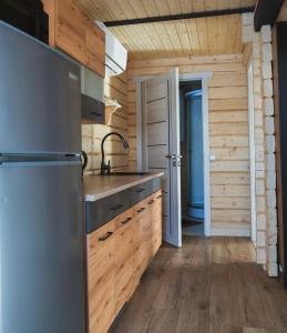 a kitchen with a refrigerator and wooden walls at Tri houses in Podobovets