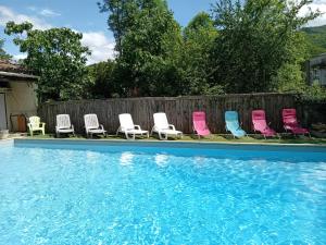 a group of chairs sitting next to a swimming pool at Hôtel La Gravenne in Thueyts +36 photos