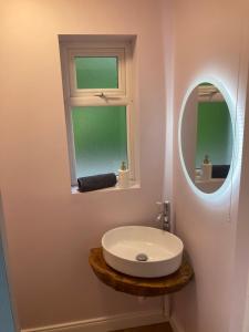 a bathroom with a white sink and a mirror at 3 bedroom Beautiful Cosy Cottage in Killashandra +12 photos