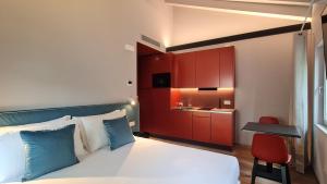a bedroom with a bed and a small kitchen at Michelangelo House, your personal Studio in Mestre +18 photos