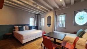 a room with two beds and a table and chairs at Michelangelo House, your personal Studio in Mestre