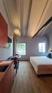 a bedroom with a bed and a desk and a kitchen at Michelangelo House, your personal Studio in Mestre