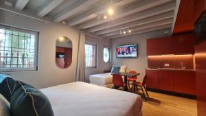 a room with two beds and a kitchen with a tv at Michelangelo House, your personal Studio in Mestre