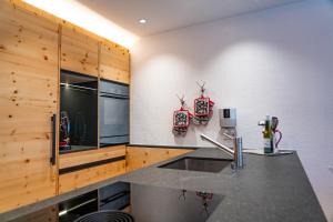 a kitchen with wooden cabinets and a counter top at Casa Calmea in Arosa