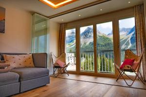 a living room with a couch and chairs and mountains at Casa Calmea in Arosa