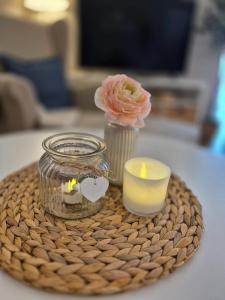 a candle and a vase with a flower on a table at MareTime - inkl Wäschepakete, 50m zum Strand in Pelzerhaken