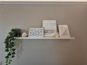 a shelf on a wall with pictures on it at MareTime - inkl Wäschepakete, 50m zum Strand in Pelzerhaken