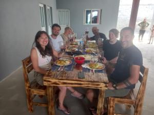 a group of people sitting around a table eating food at Casa Pirinha in Portela