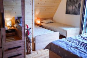 a small bedroom with two beds and a mirror at Planinska kuća Vista in Mrkopalj