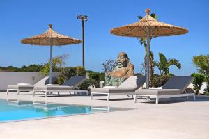 a statue of a man sitting next to a pool at Cape Serenity Mansion in Ayia Napa