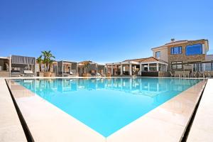 a large swimming pool with blue water at Cape Serenity Mansion in Ayia Napa