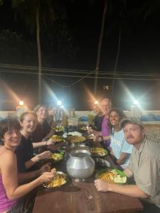 a group of people sitting around a table eating food at FREEDOM HOUSE, Munroe Island , Kollam - A Backpackers Hostel in Munroe Island
