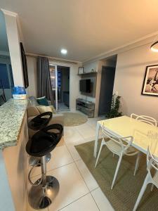 a kitchen and living room with a table and chairs at ACONCHEGO E BEM ESTAR in Brasília