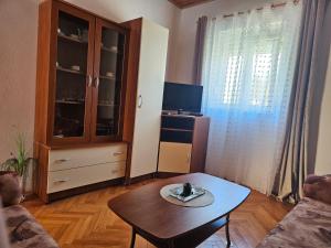 a living room with a coffee table and a tv at Apartment Tičić in Povljana