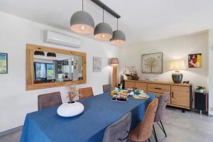 a dining room with a blue table and chairs at Au Cerf Blanc Suite Parentale in Les Eyzies-de-Tayac