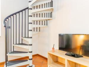 a spiral staircase next to a tv and a stair case at White Nest - Lake Como & Ski Area in Ballabio