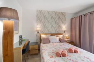 a bedroom with a bed with pink pillows on it at Au Cerf Blanc Suite Parentale in Les Eyzies-de-Tayac