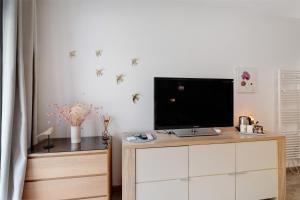 a living room with a tv on top of a dresser at Au Cerf Blanc Suite Parentale in Les Eyzies-de-Tayac