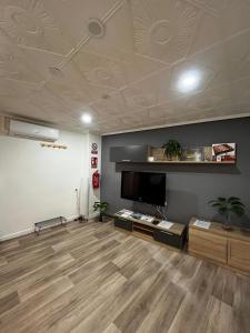 a living room with a flat screen tv and wooden floors at Casa Sempere in Elche