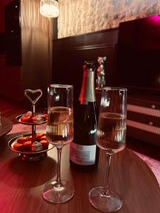 a bottle of wine and two glasses on a table at Clos des Voluptés in Fargues-Saint-Hilaire