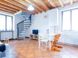 a living room with a table and a spiral staircase at White Nest - Lake Como & Ski Area in Ballabio