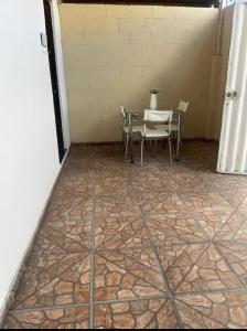 a patio with a table and chairs on a tiled floor at Lar sossego Itabuna in Itabuna +1 photo