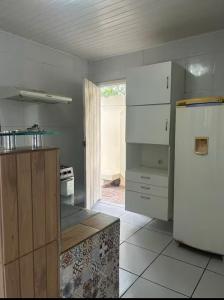 a kitchen with a white refrigerator and a stove at Lar sossego Itabuna in Itabuna