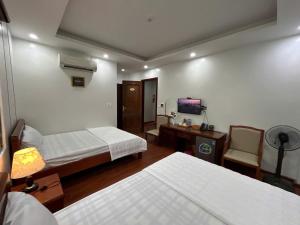 a hotel room with two beds and a television at Sam Son Golden Dream Hotel in Sầm Sơn