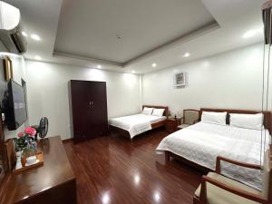 a hotel room with two beds and a television at Sam Son Golden Dream Hotel in Sầm Sơn