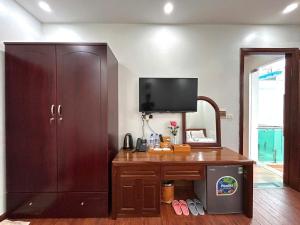 a room with a wooden desk with a large cabinet at Sam Son Golden Dream Hotel in Sầm Sơn