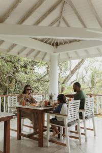 a group of people sitting around a wooden table at Good Vibes Villas in Unawatuna