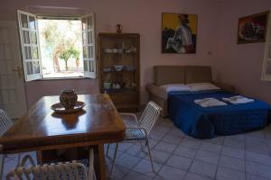 a living room with a bed and a table and a room with a couch at Il Giardino sul Mare in Acquedolci