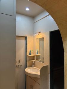 a bathroom with a sink and a mirror at The Highstreet Stay in Pune