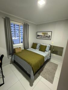 a bedroom with a bed and a large window at ACONCHEGO E BEM ESTAR in Brasília +23 photos