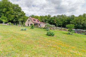 a house on a hill with a field of grass at Au Cerf Blanc Suite Parentale in Les Eyzies-de-Tayac