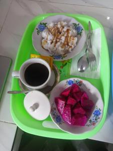a green tray with two plates of food and a cup of coffee at Kersa Guest House in Sidemen