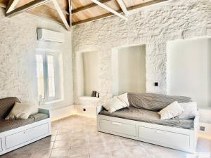 a living room with two couches and a stone wall at Anna home Elafonisos in Elafonisos