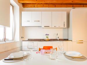 a kitchen with a table with plates and glasses at White Nest - Lake Como & Ski Area in Ballabio +28 photos