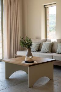 a living room with a table with a vase on it at Vedema Homes in Lefkogeia
