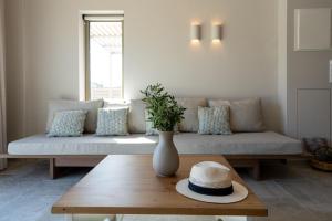 a living room with a couch with a hat on a table at Vedema Homes in Lefkogeia