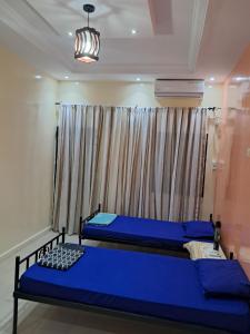 a bedroom with two blue beds and a window at La paix bis in Saint-Louis
