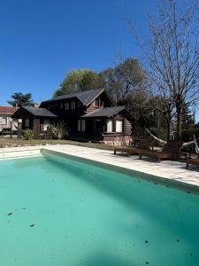 a house with a swimming pool in front of a house at La Secreta in Villa Giardino
