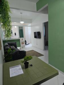 a living room with a table and a couch at Apartamentos - Repouso do Guerreiro in Itabuna